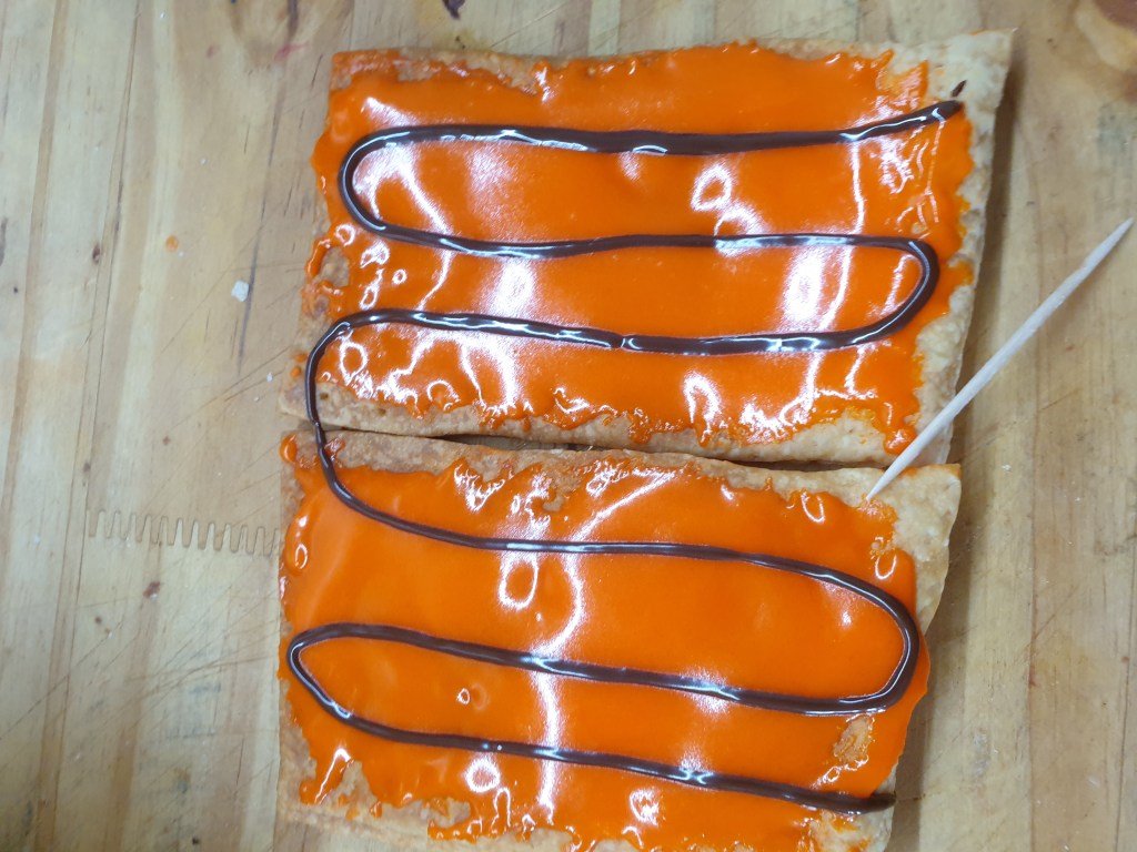 Oranje glazuur met chocolade strepen.