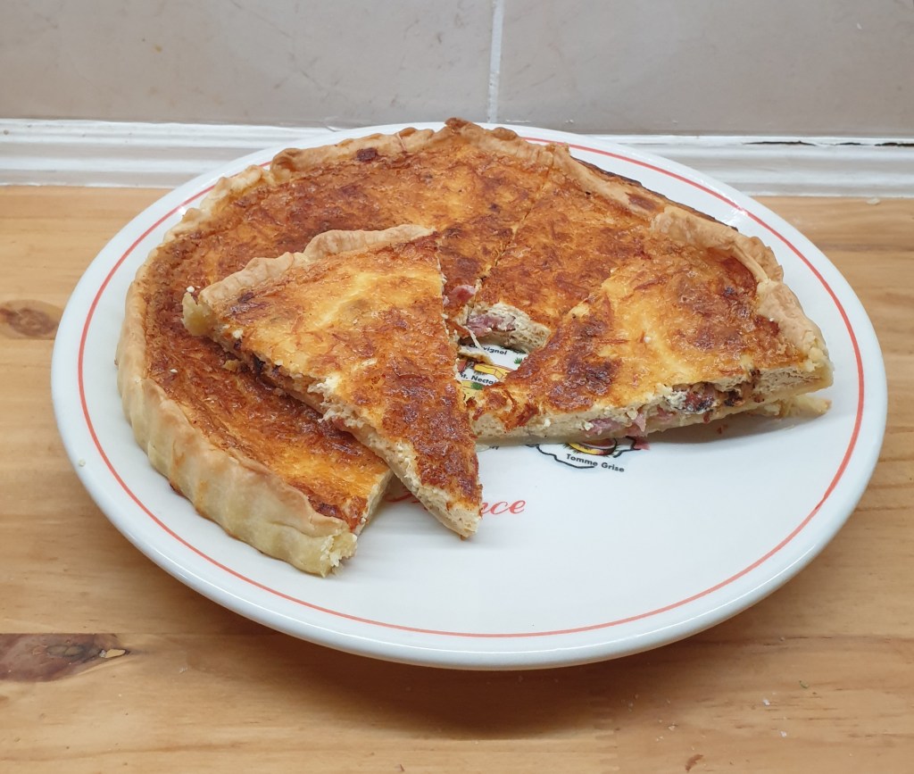De Quiche Lorraine, een klassieker uit de Franse keuken, combineert op meesterlijke wijze spek, crème fraîche, en eieren in een rijke, hartige taart.