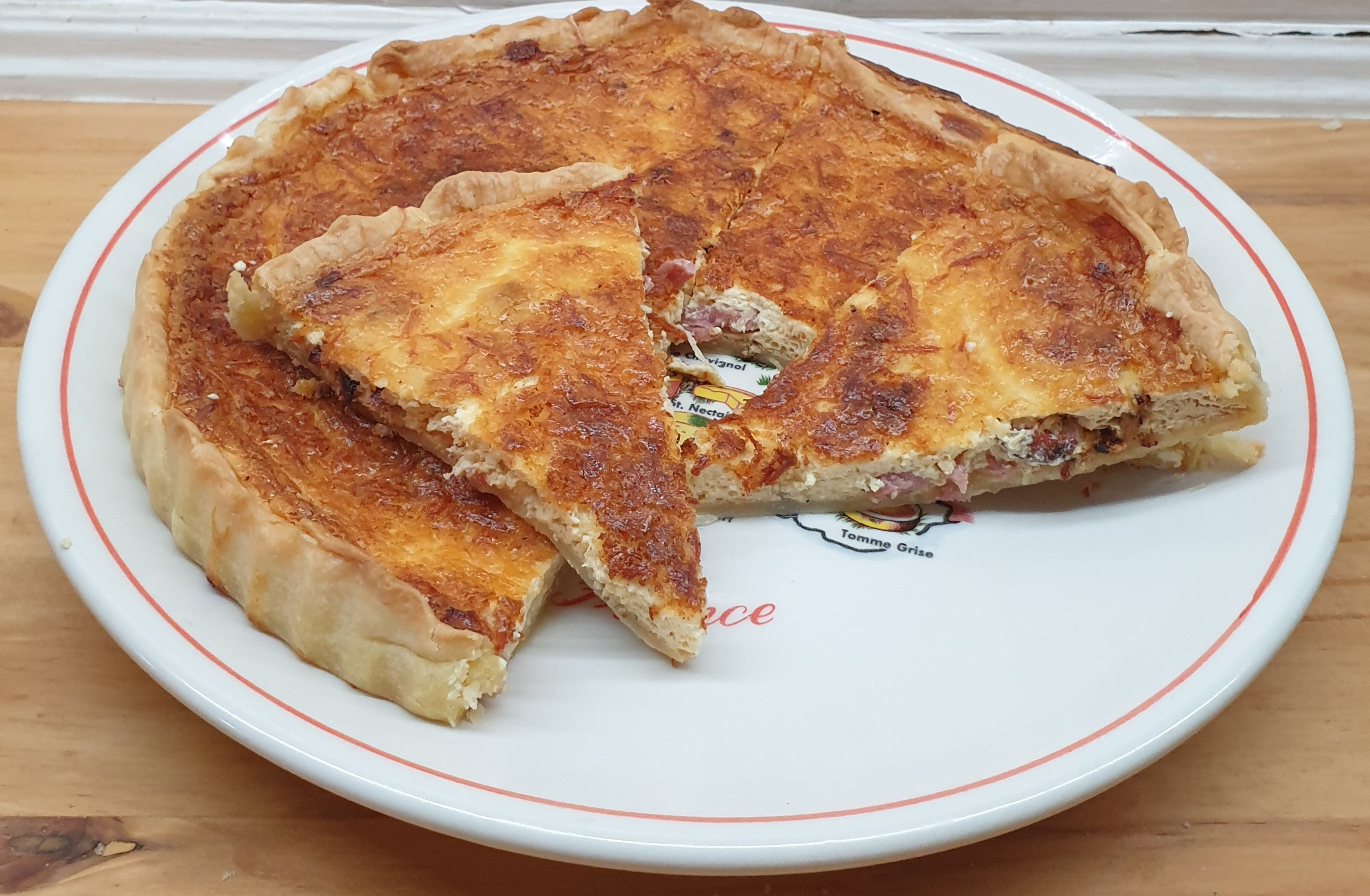 Traditionele Quiche Lorraine met romige vulling en knapperige spekjes, en eventueel geraspte Gruyères kaas.